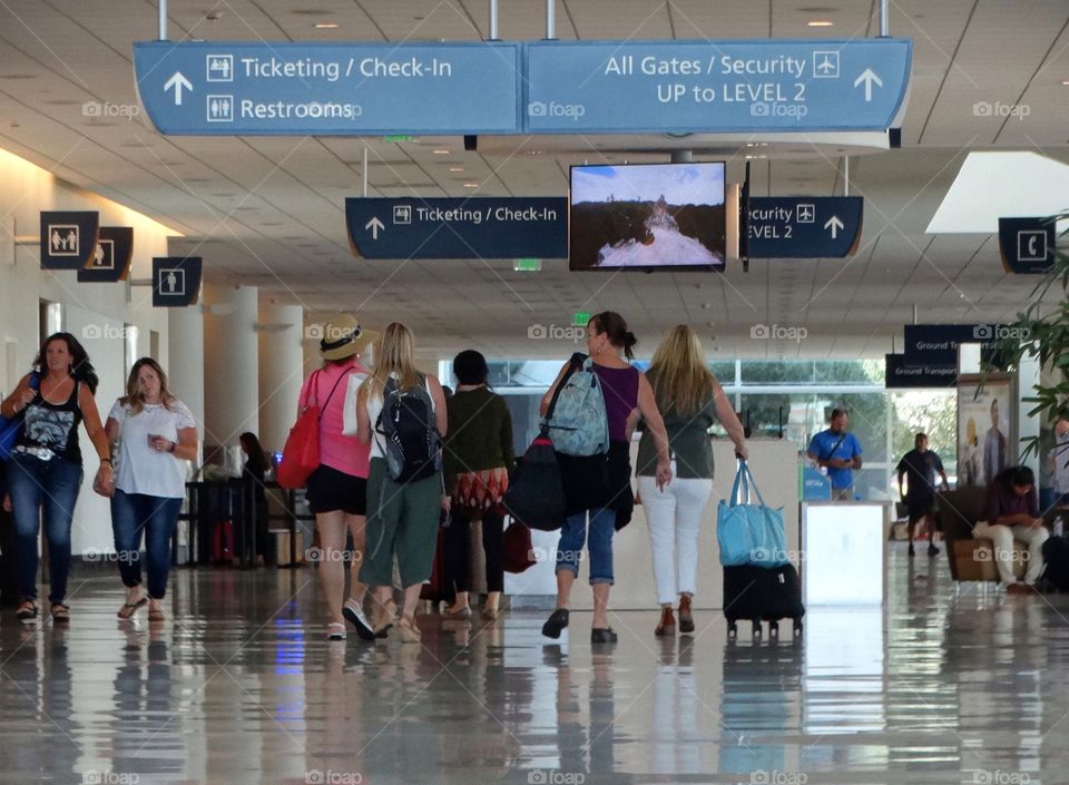 Travelers Walking Through An Airport Terminal
