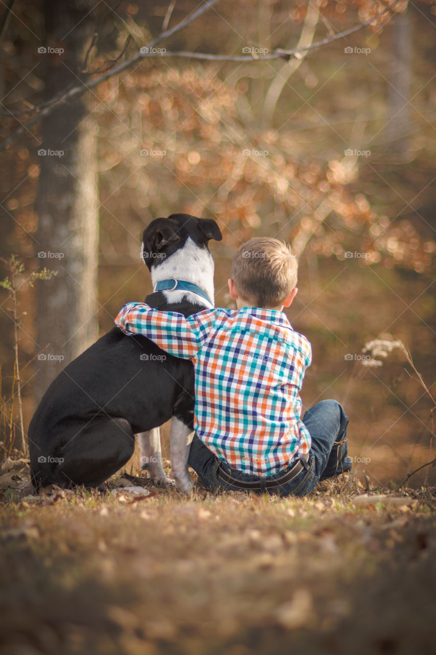 Young Boy Hugging His Dog Outside 