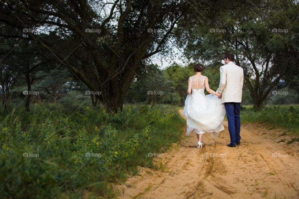 Love, photographed - wedding couple walking on sand road