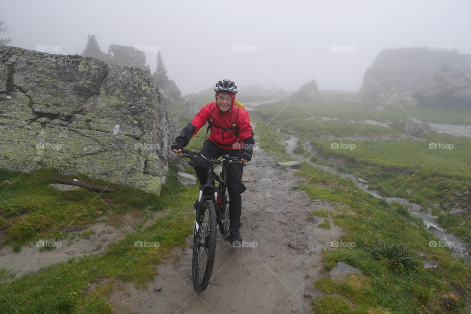 Mountainbiker in a high valley on a foggy day