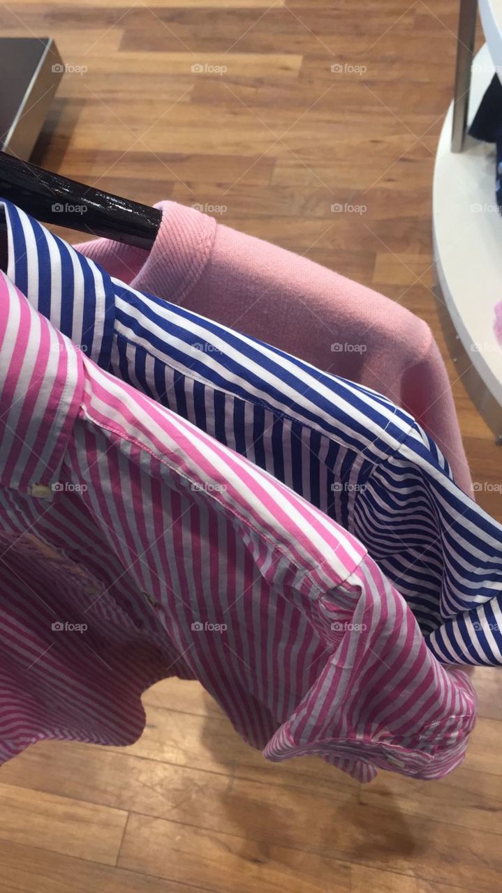 The corner of 3 tops, a pink stripy shirt a blue striped shirt and a pink sweater or jumper. Ralph Lauren 
