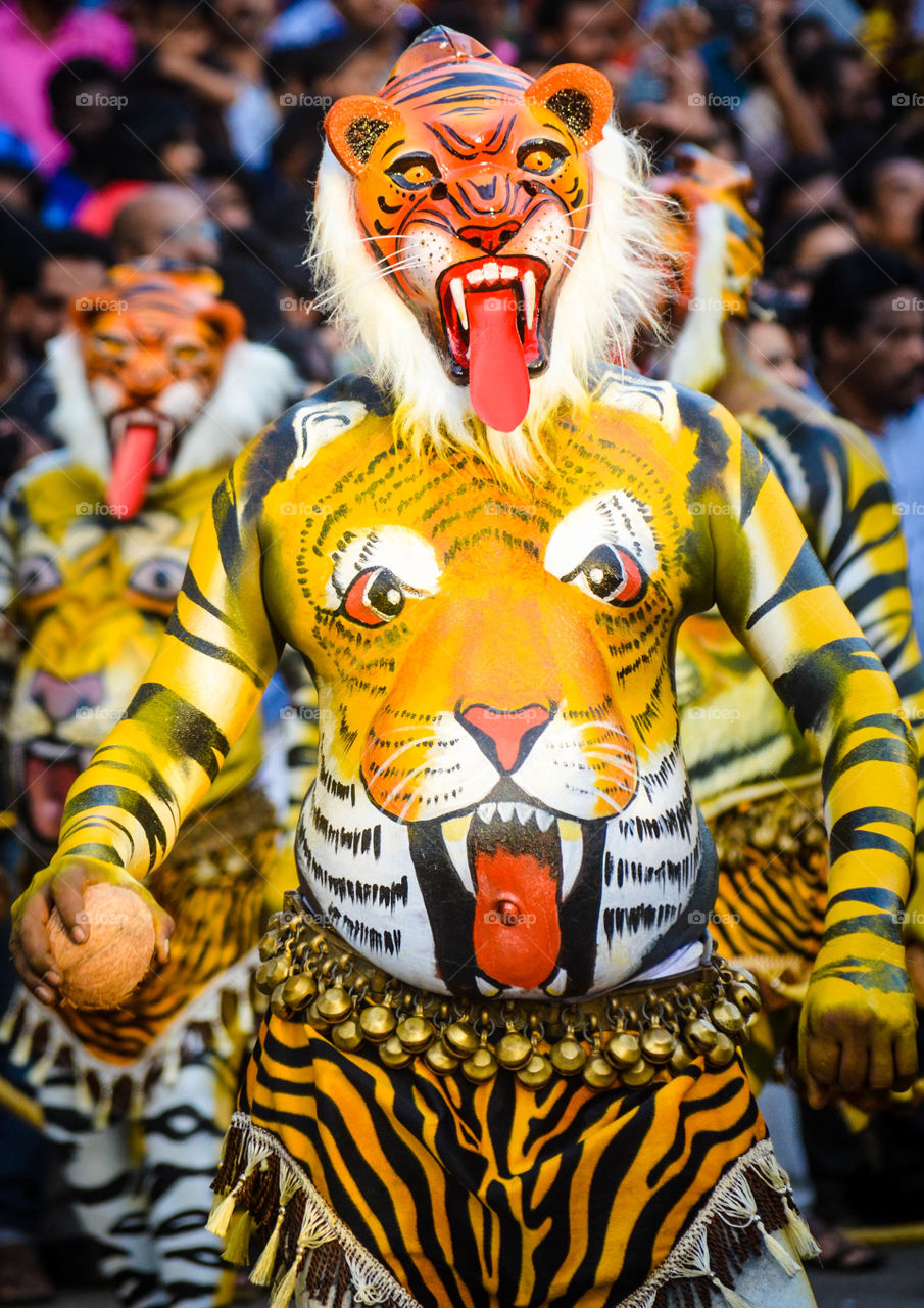 Close-up of a person with tiger mask and body paint