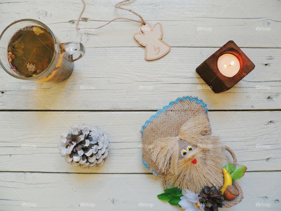 cup of tea, crafts, candle and an angel on the table