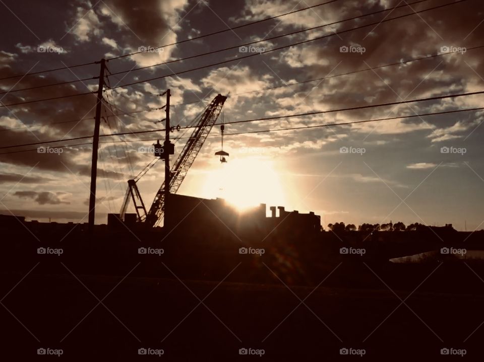 Construction crane setting down the Sun after a long Florida day 