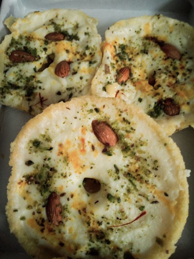 Ghevar is an Indian Rajasthani cuisine sweet traditionally associated with the Teej Festival. 
​It is disc-shaped sweet cake made with maida (refined wheat flour) and soaked in sugar syrup.