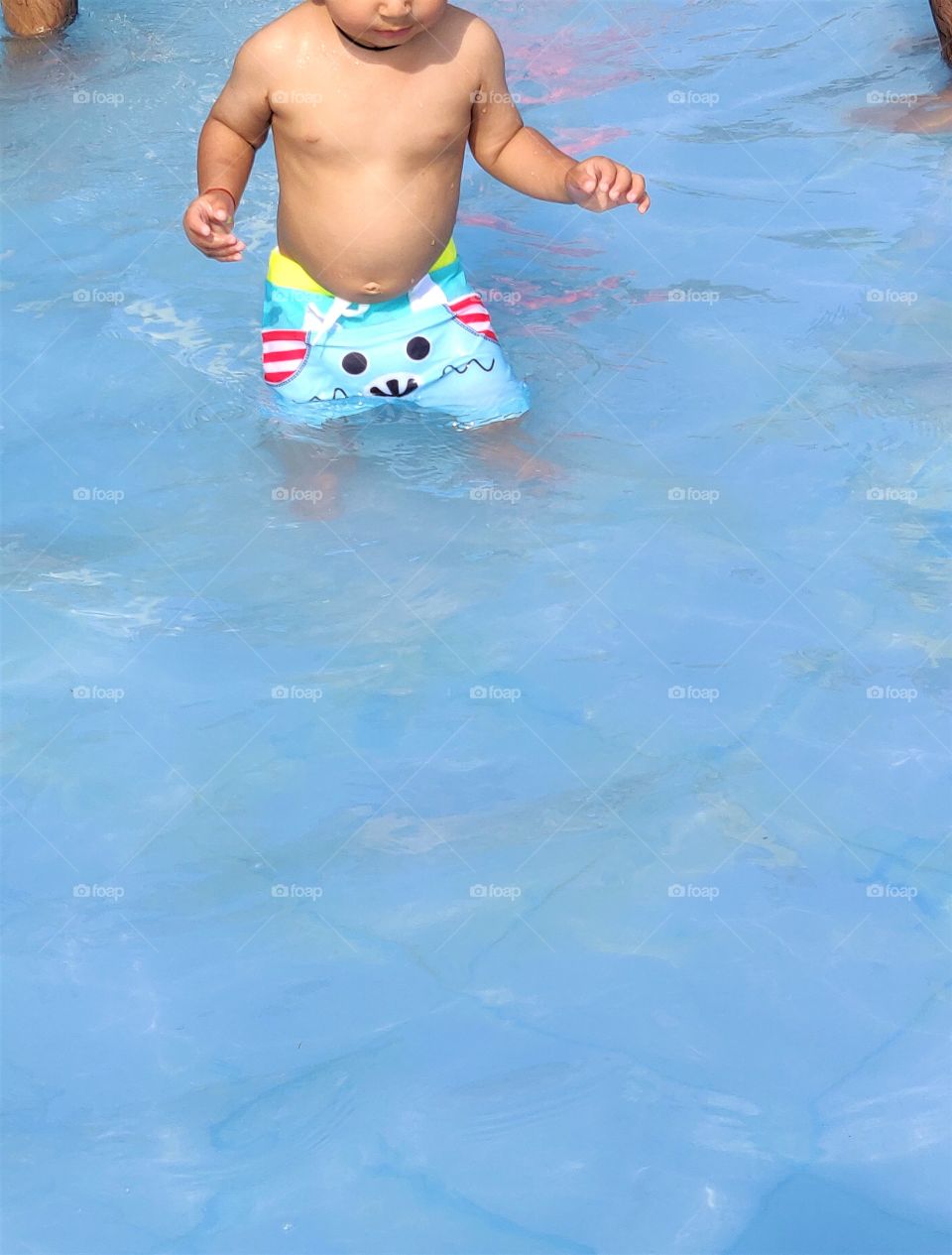 toddler inside a dug-out-pool in summer