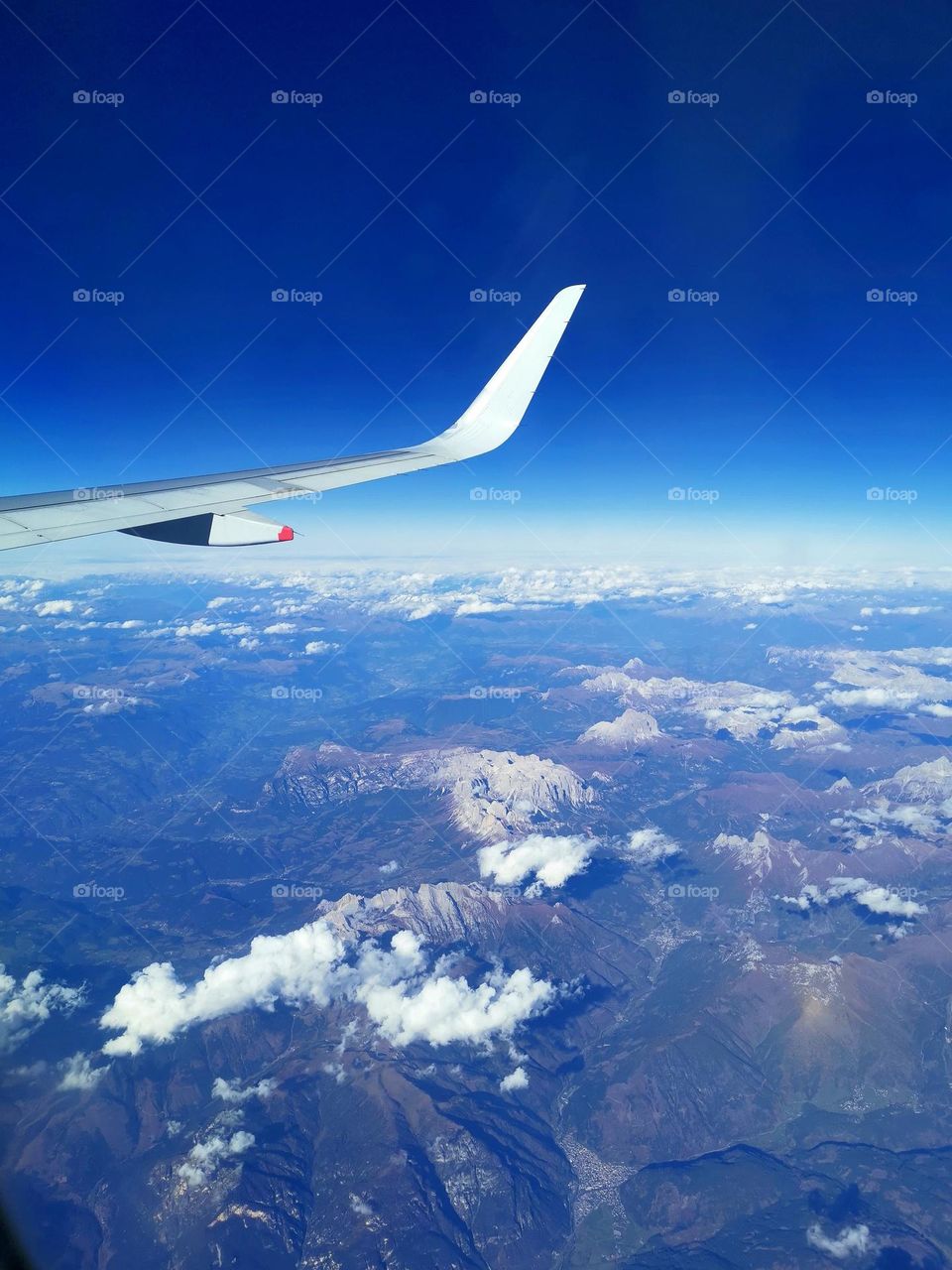 View under the wing of the aircraft. View from above. Blue sky.