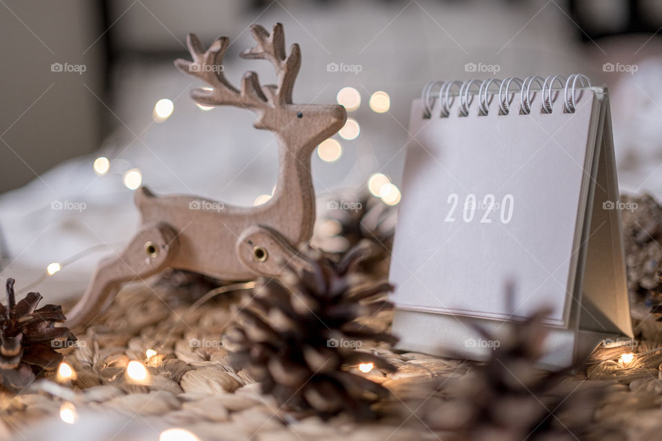 2020 new year grey calendar with cones and wooden deer and lights on rustic server