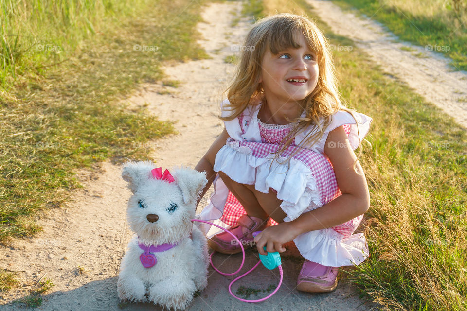 Little girl is playing with her toy dog