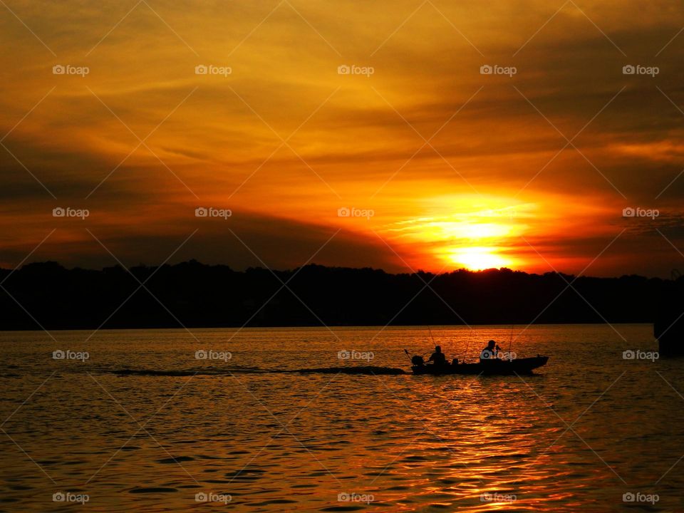 Silhouette of Fishermen heading in after catching the big one 