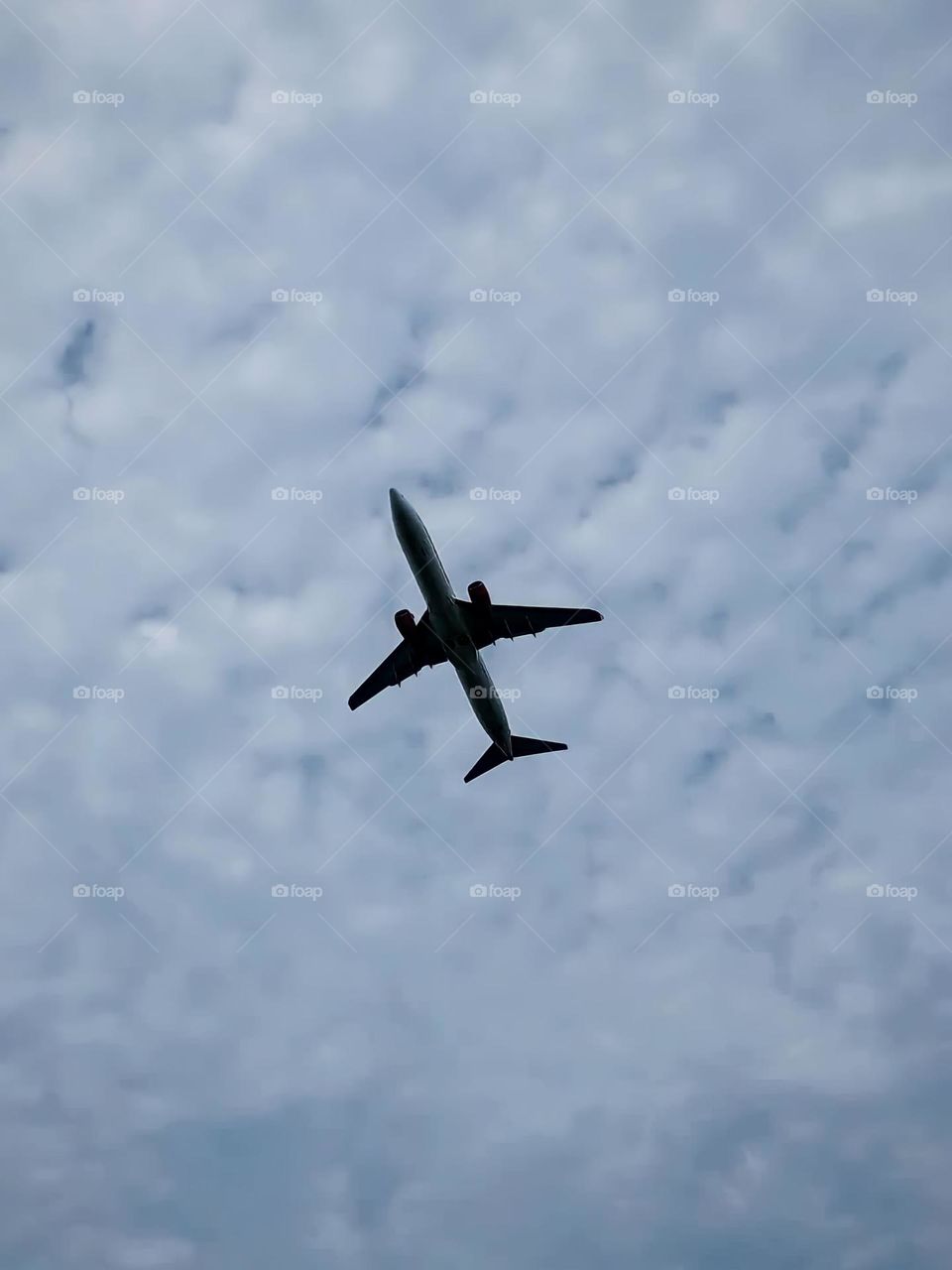 Close-up view of a plane flying in a cloudy sky. Planes with large wings are seen flying high in the sky in low angle view