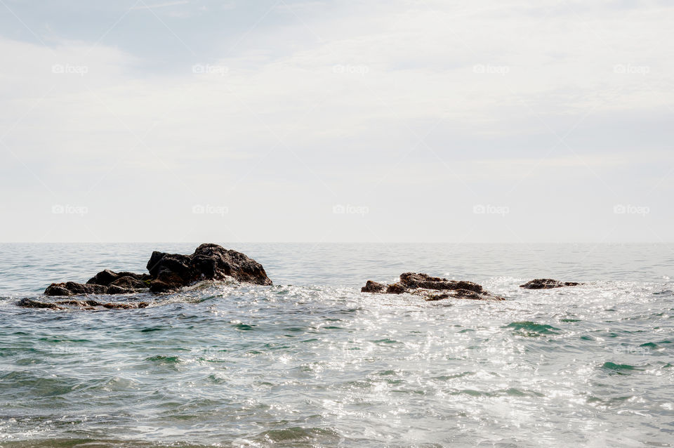 Sea rocks emerging during sunny day.