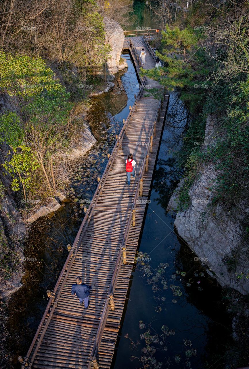 People walking on the wooden bridge.