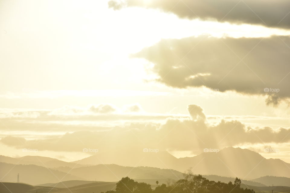 Evening light streaming through the clouds