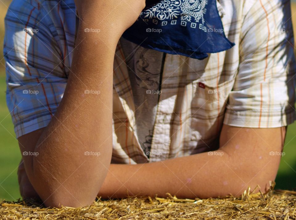 A young man relaxing with the support of hay bales on a sunny fall day in Central Oregon. 