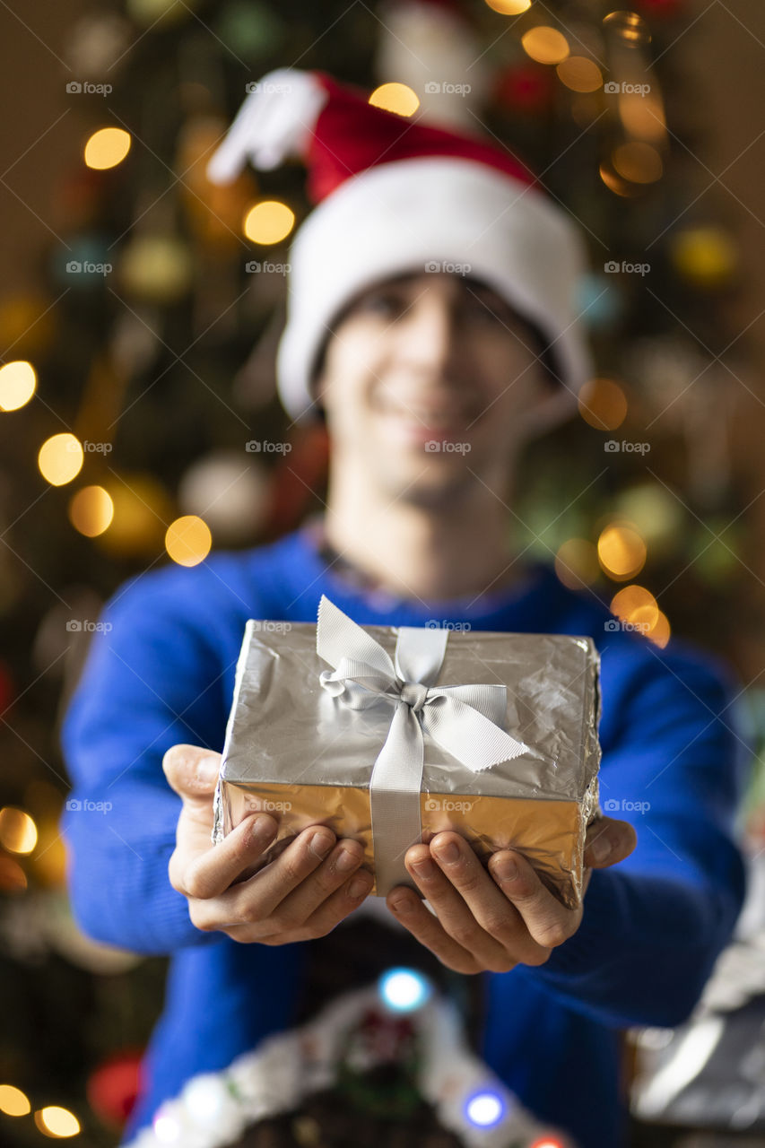 A man giving a shinny present on christmas morning