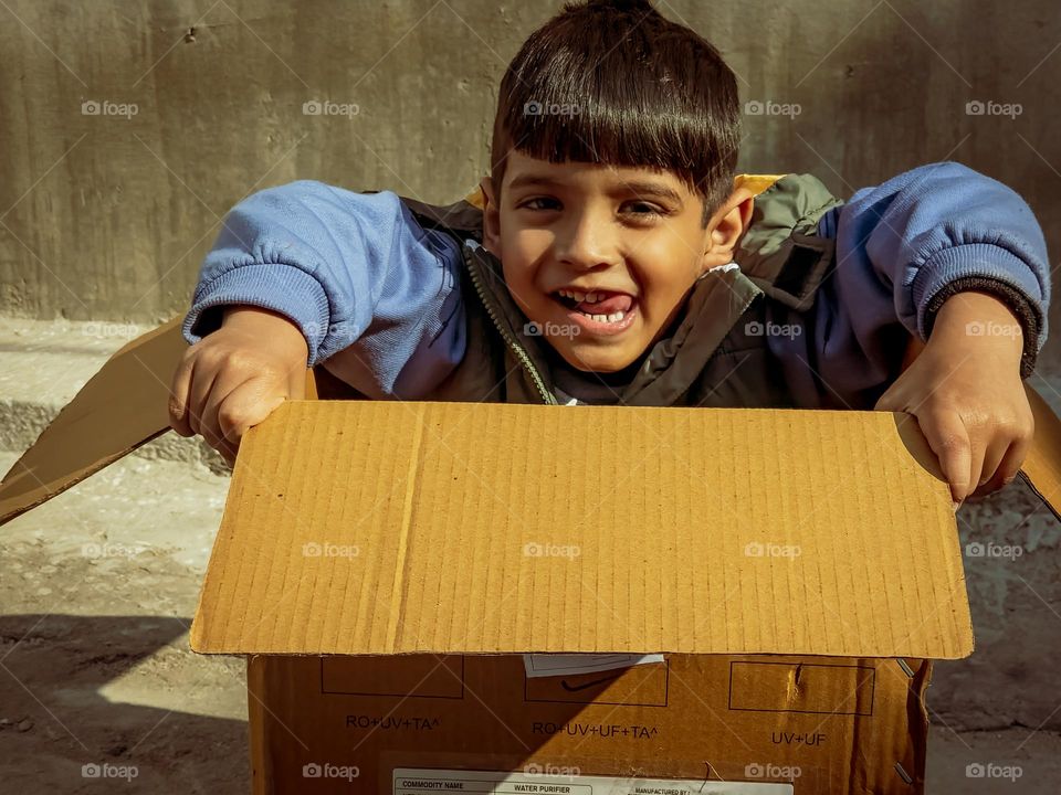 Mobile phone nowadays have taken the childish game away from childhood I found this kid playing with delivery box which made me remember my own childhood