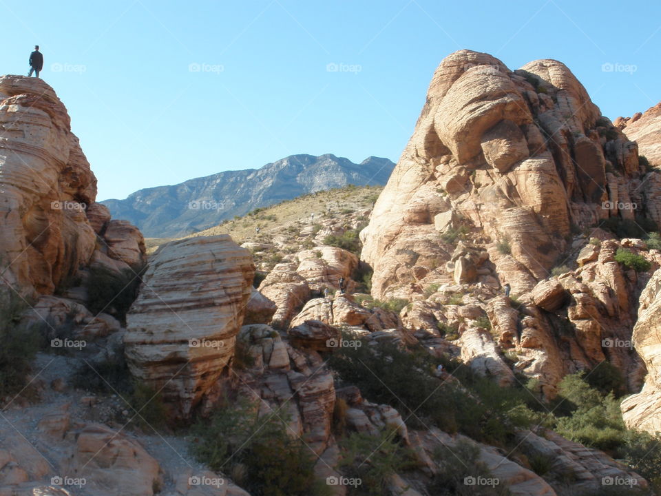 Standing on Top of the World. Man standing on boulder at Red Rock Canyon. 