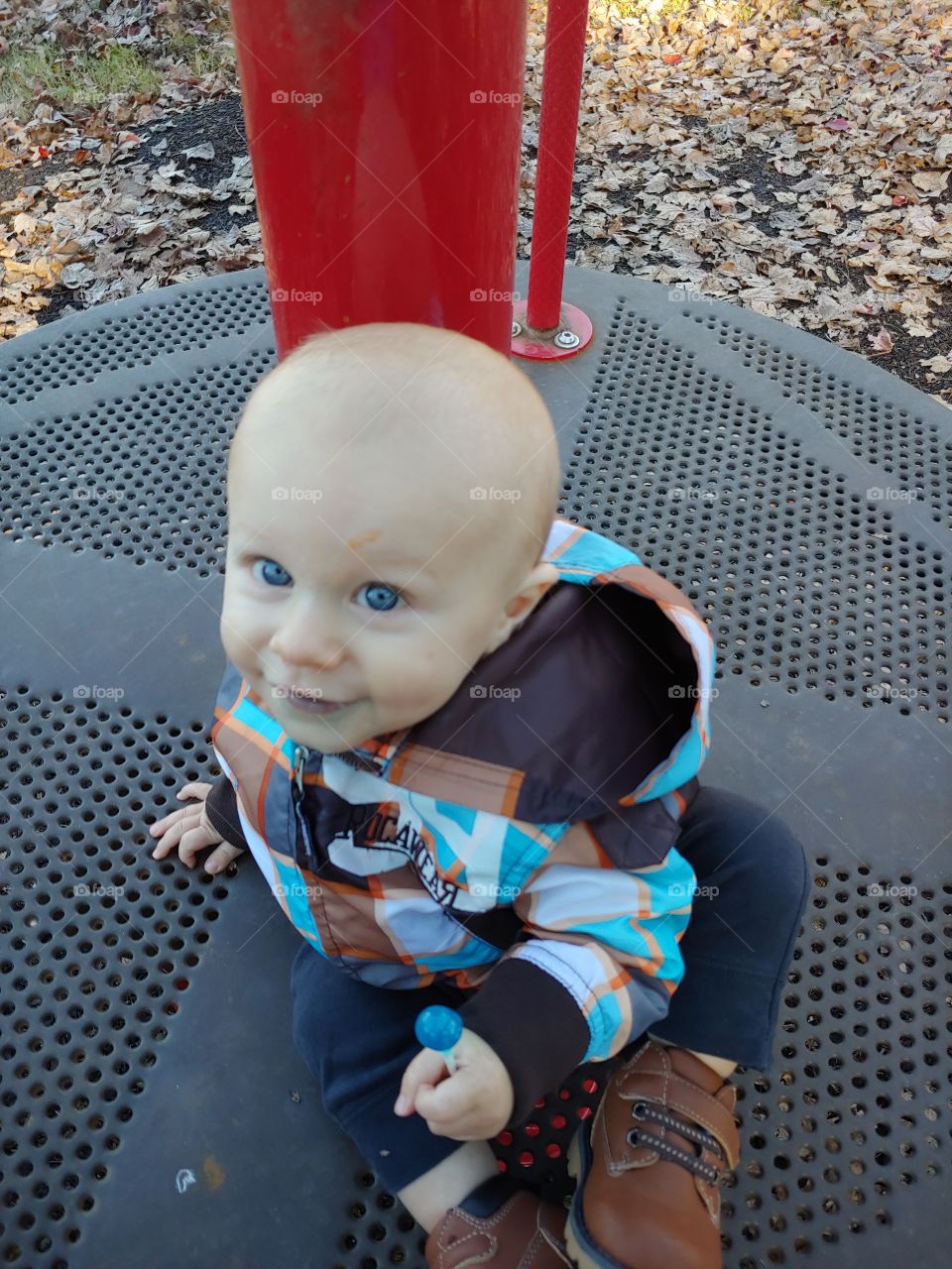 toddler at the playground with a lolly pop