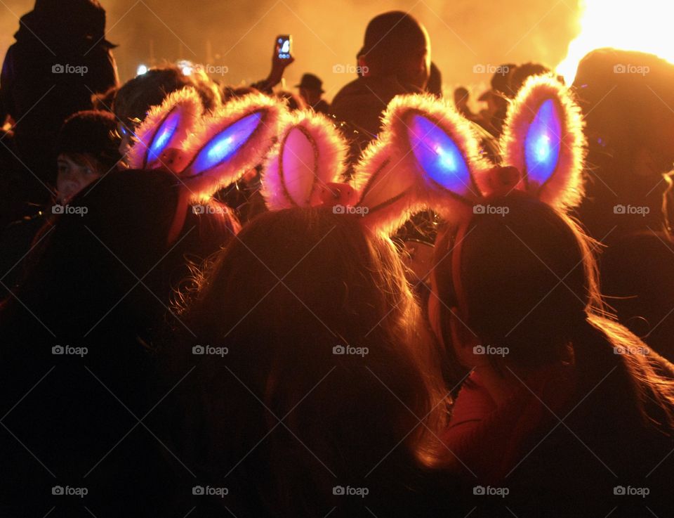 3 sets of bunny ears on top on the heads of teenage girls attending a bonfire