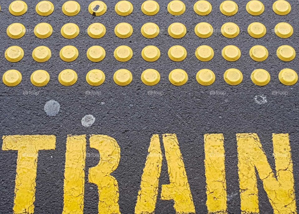 The yellow train station signs written on the concrete non slip for safety. Wellington. N.Z.