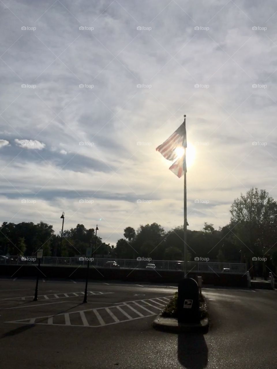 Sun setting behind American and Florida flags 