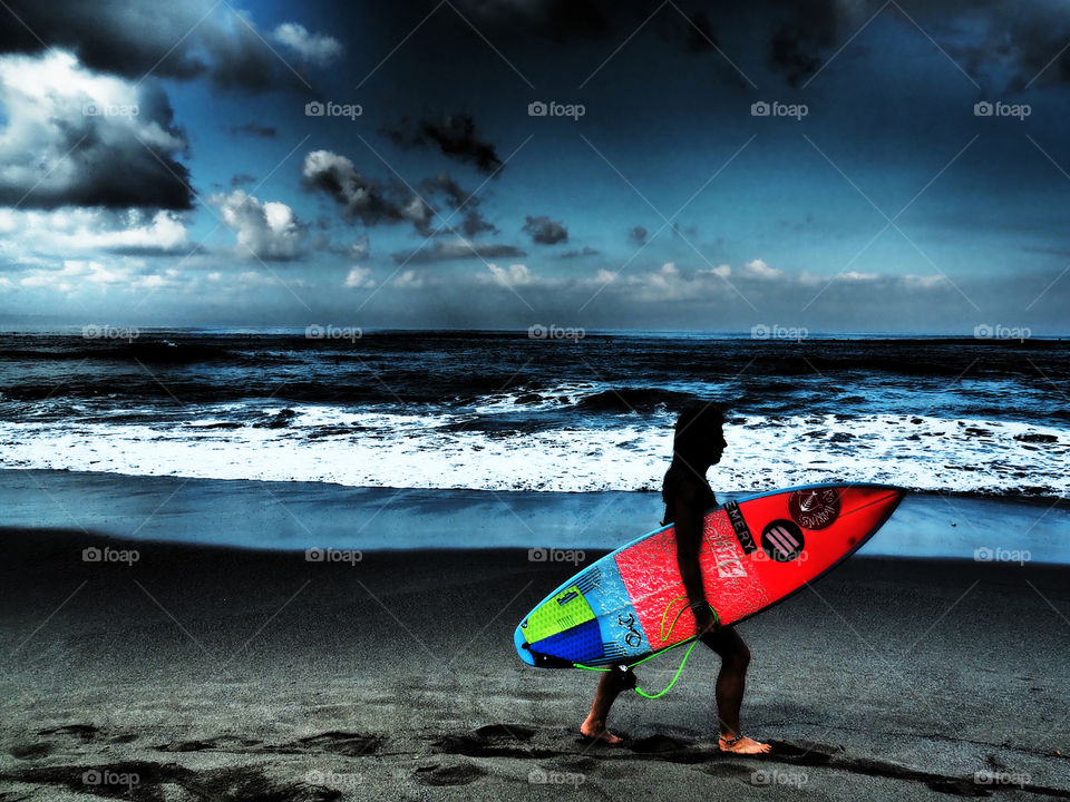 Female surfer on beach with surfboard 