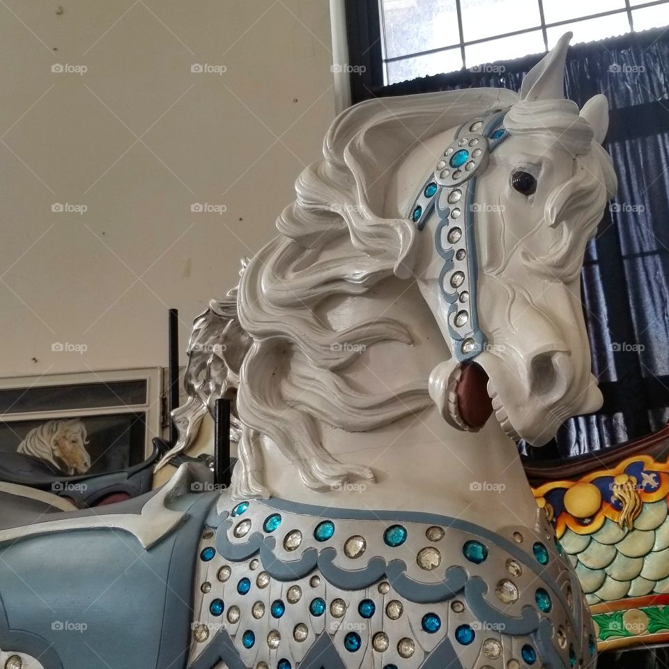 White painted carousel horse with silver and blue embellishments at a museum in Sandusky, Ohio