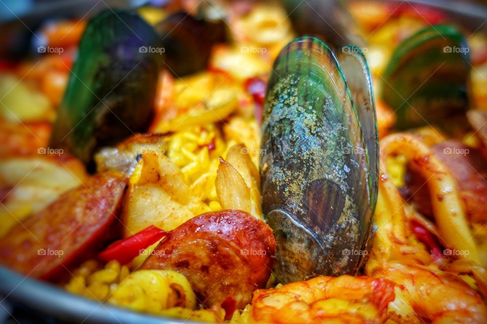 Close up of Spanish paella - consisting of saffron rice, chorizo, vegetables and various seafood.