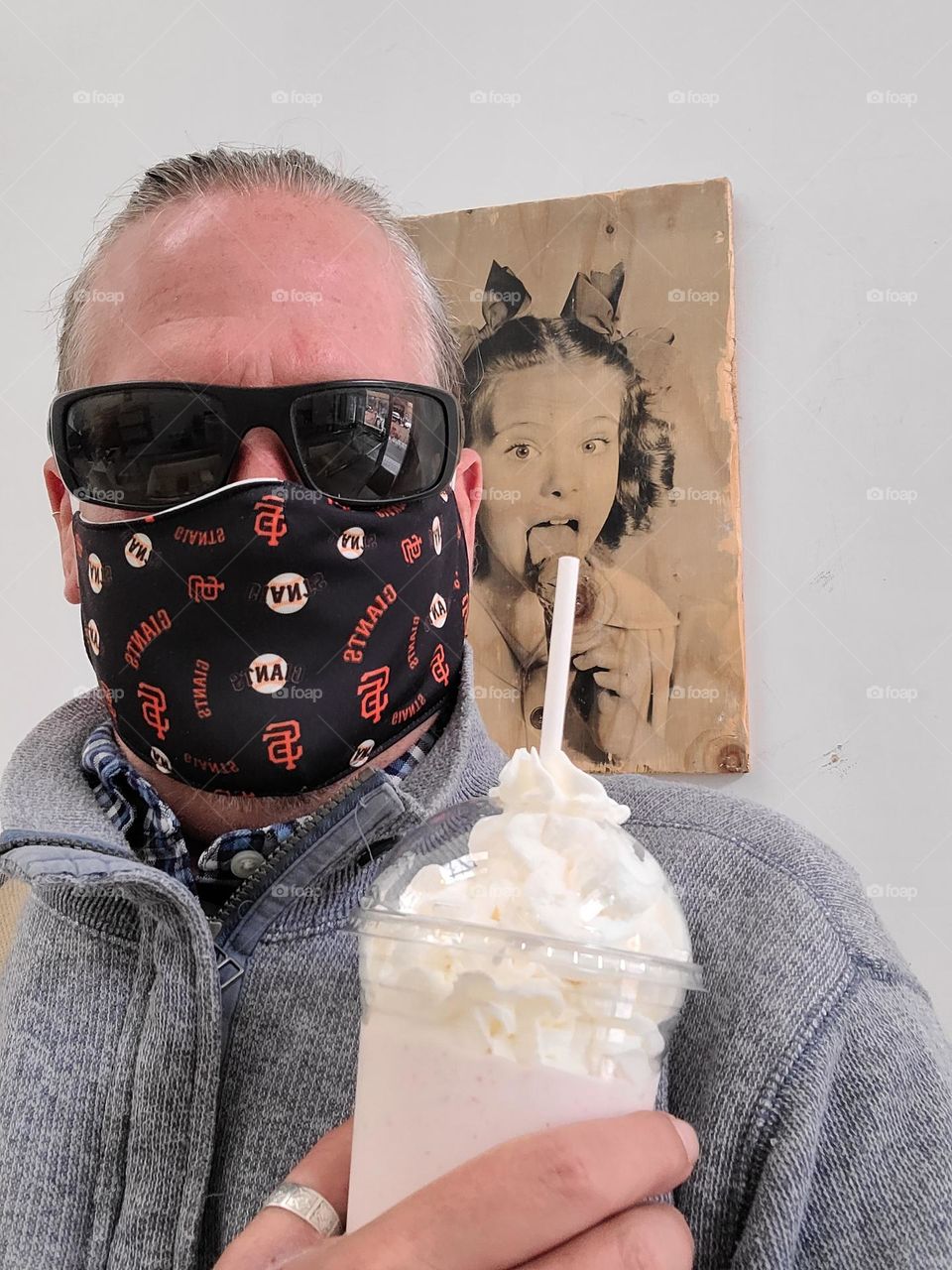 Masked up while enjoying a root beer float at at an ice cream parlor, funny picture in the background 