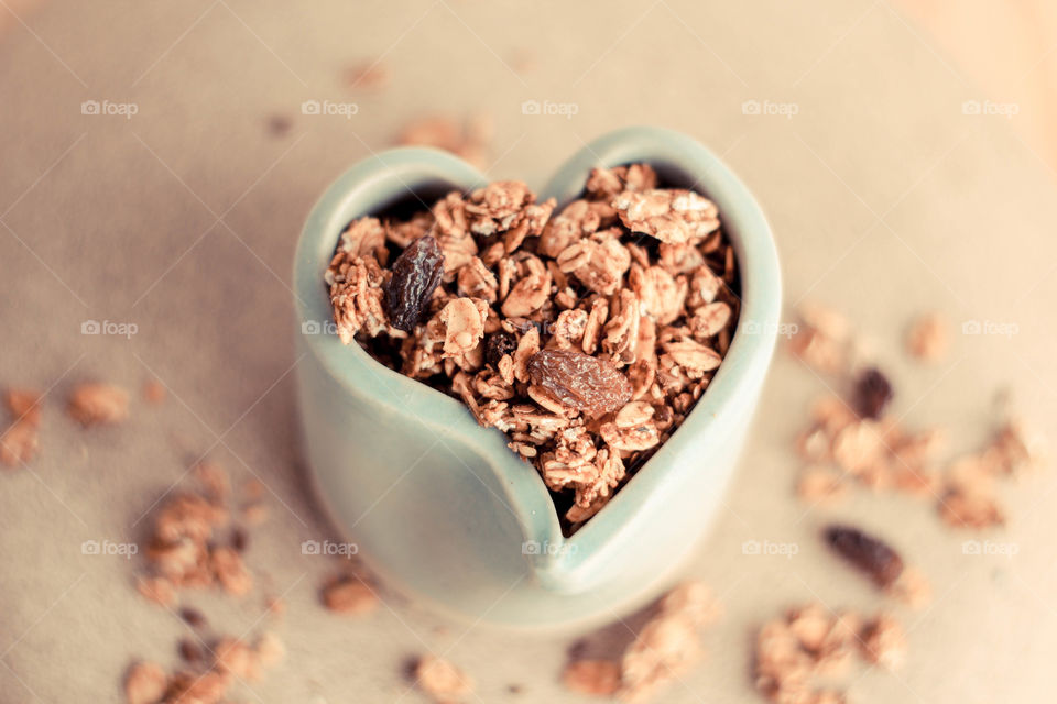 Granola and raisin in heart bowl shape