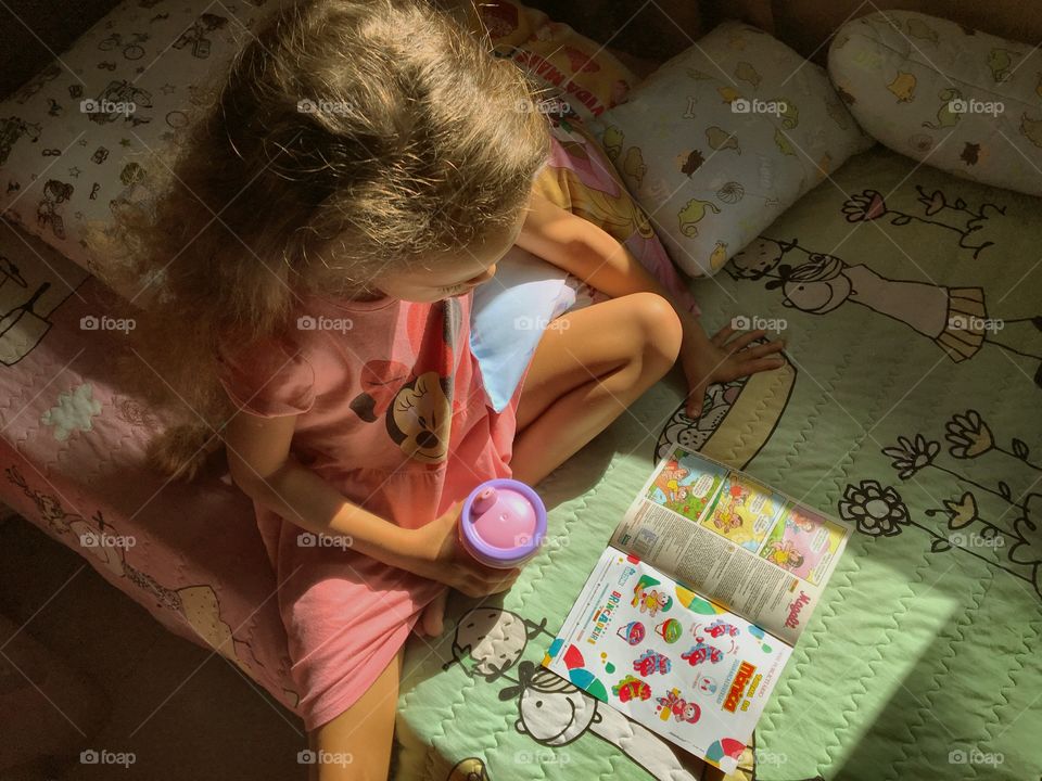 Little girl entertained with comics