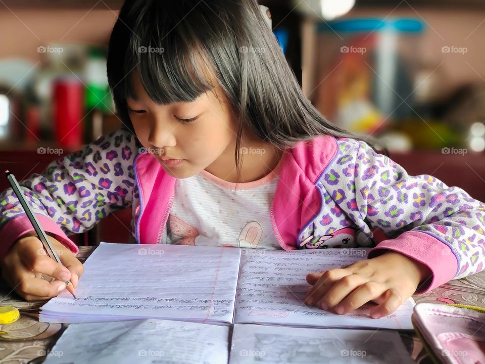 Schools have started again, a little doing her homework.