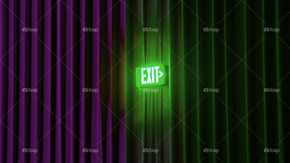 Movie theater curtains divide into purple and green vibrantly with a glowing neon exit sign to stage right.
