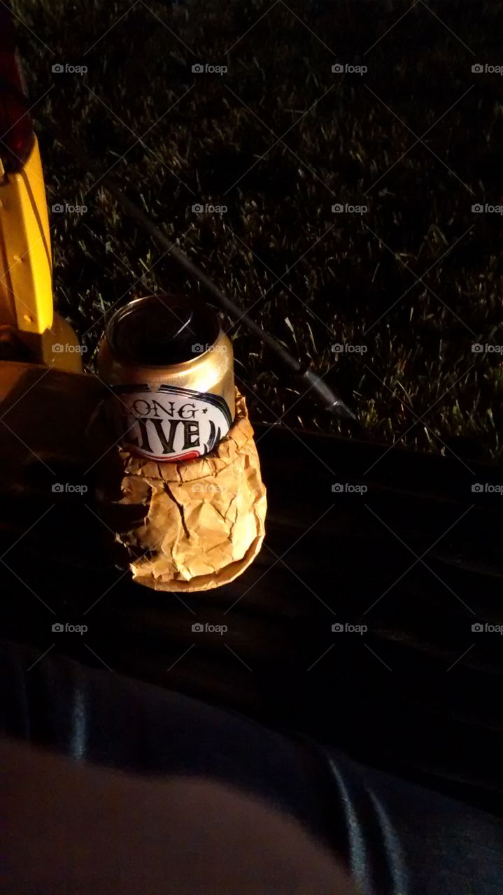 Beer Can on Tailgate. After Country USA sitting on a tailgate. Beer is in a brown paper bag coozi 