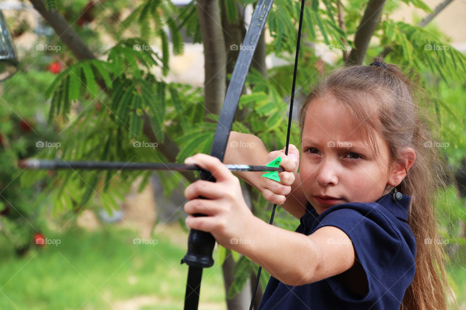 Child shooting bow and arrow