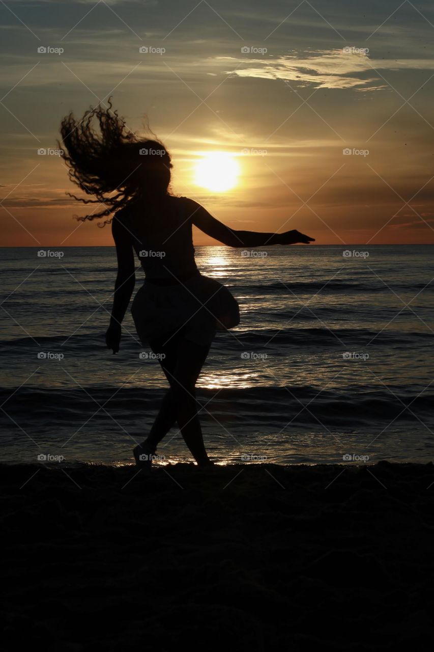 Dancing girl on the rays of the setting sun.