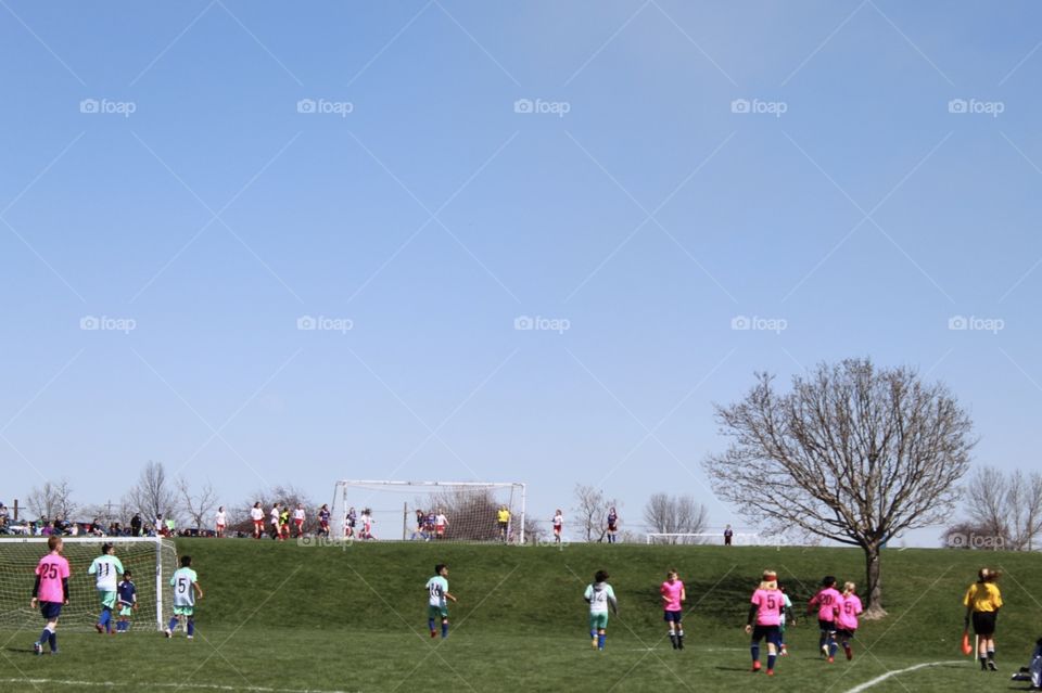 Kids playing soccer in a beautiful spring day 