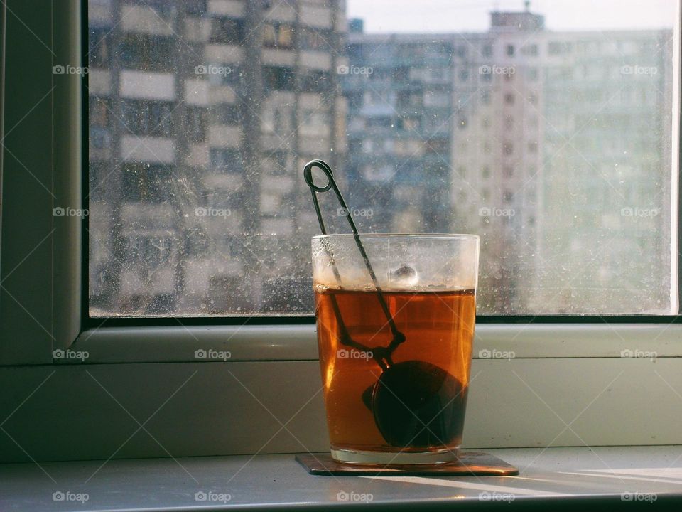 a cup of black tea on the windowsill