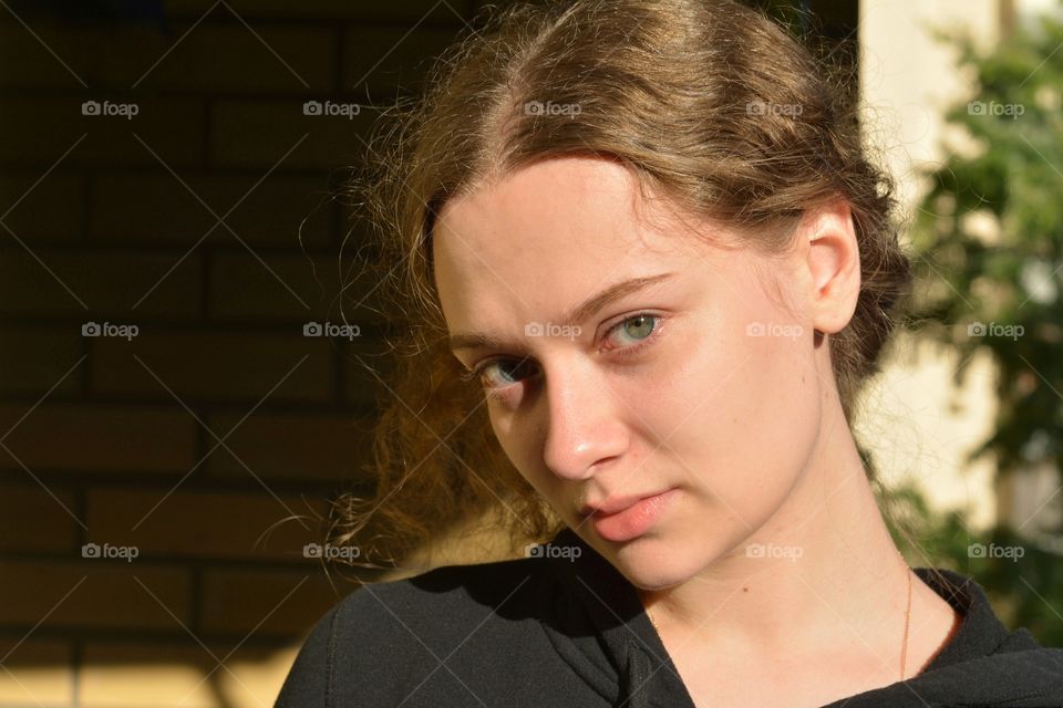 girl beautiful portrait close up in sunlight brick wall background