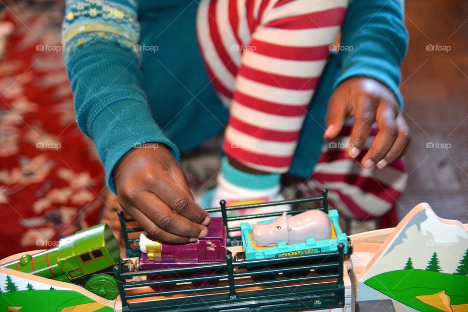 African American girl playing with train set