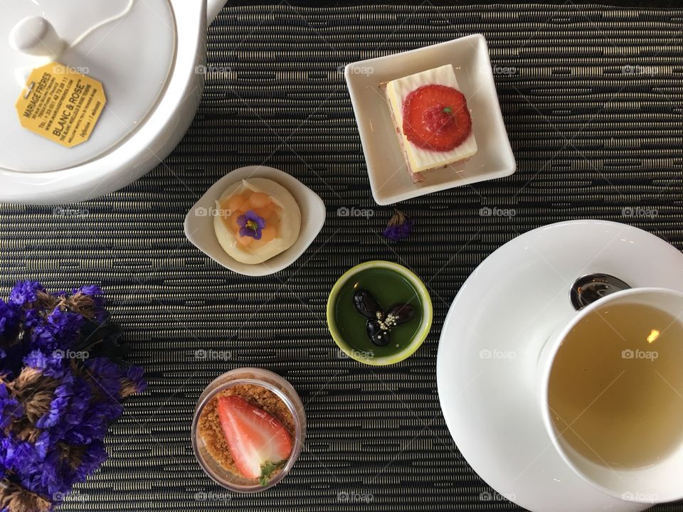 A white glass of tea with strawberry cake