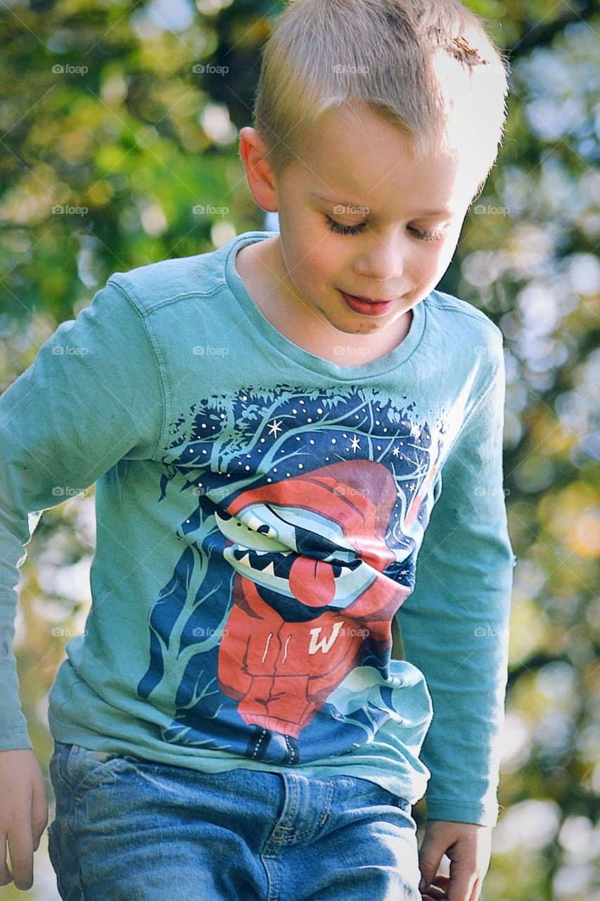 Portrait of a cute shy boy looking down