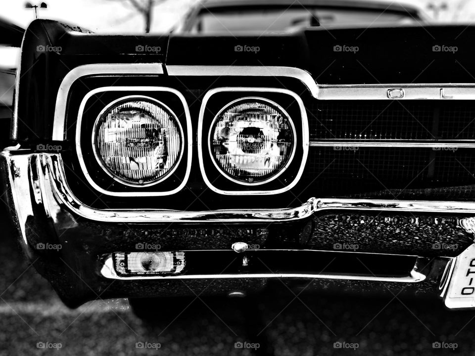 Vintage Oldsmobile car headlights, front end of an Oldsmobile car, monochrome car photo 