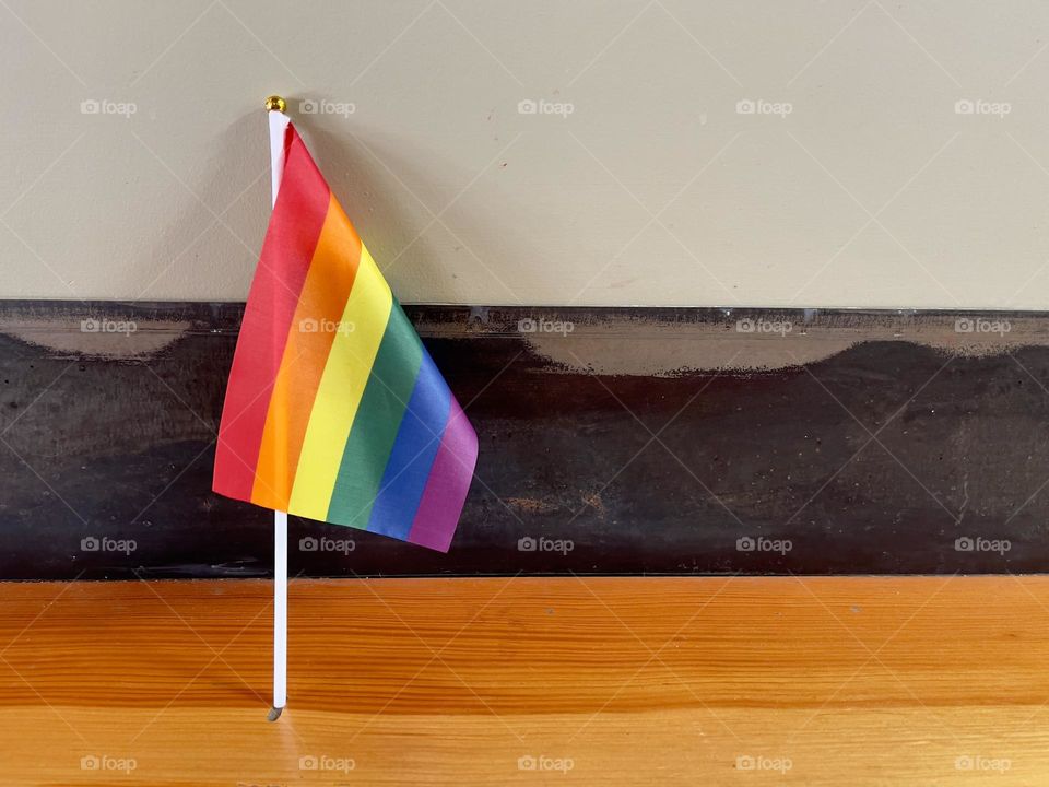 Pride flag stands near the wall