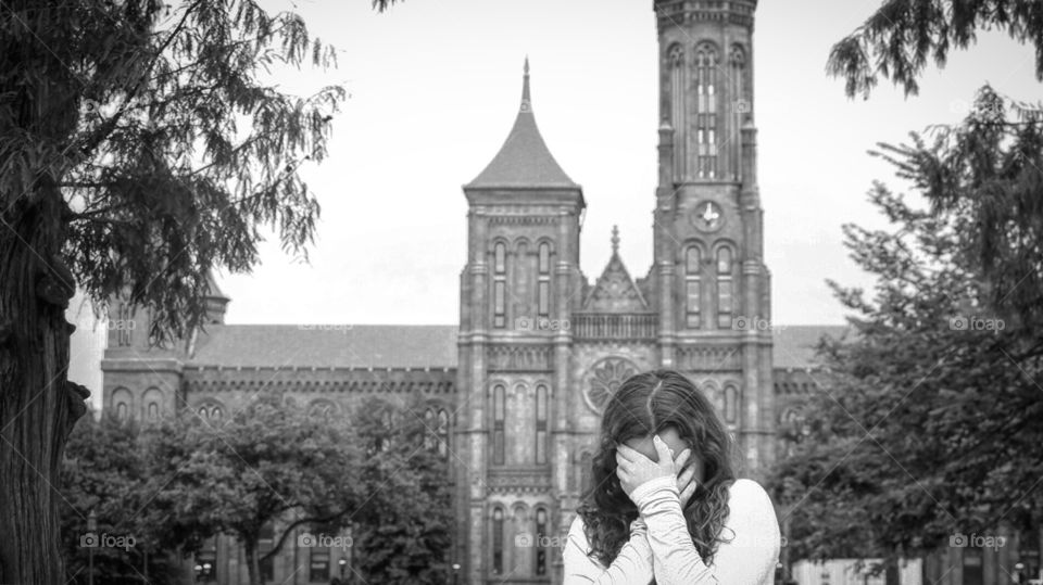 Monochrome girl facepalm over antique architecture