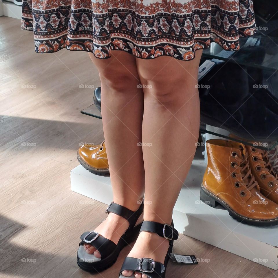ladies legsand feet trying on sandles in shop