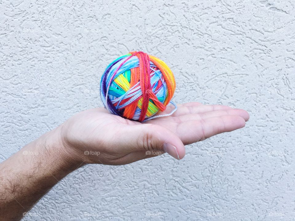 Man's hand holding ball of wool
