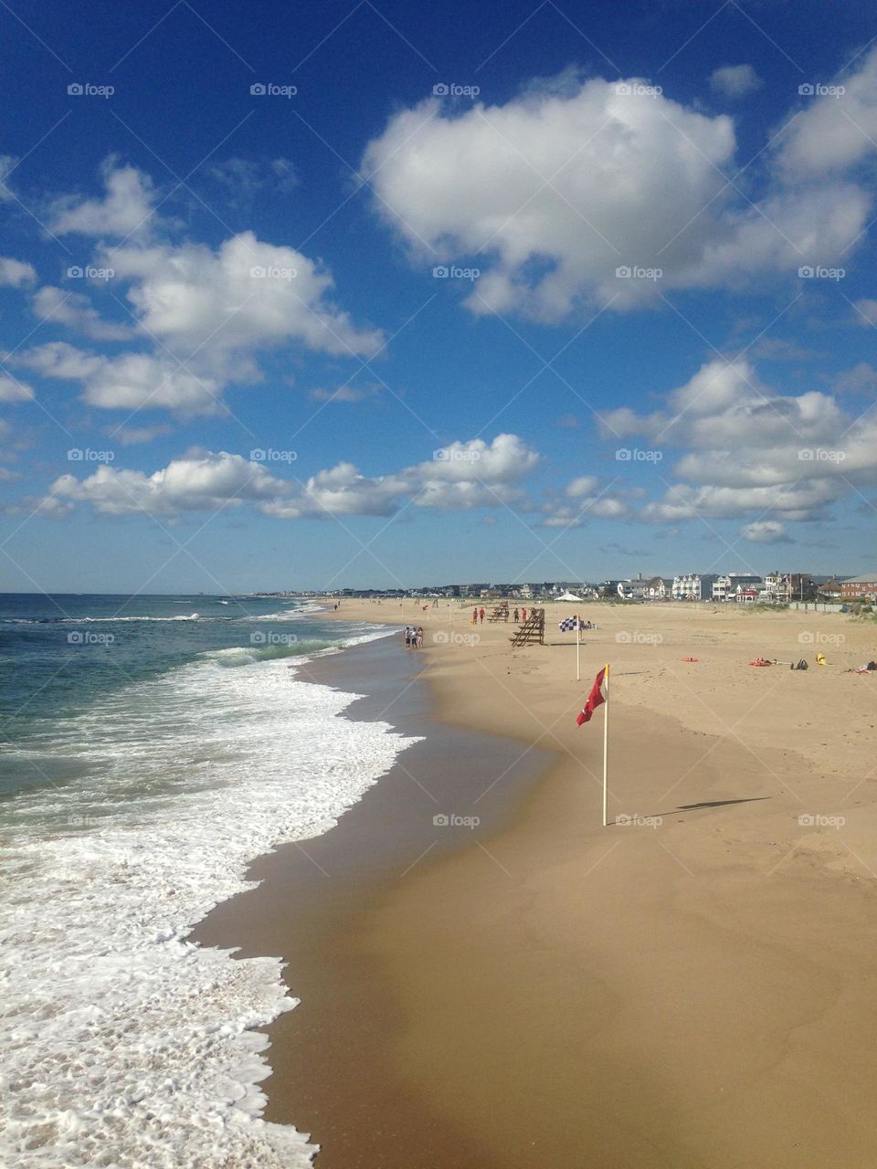 Puffy, fluffy white clouds “floating” in the sky above the ocean and beach in Ocean Grove, N.J., looking toward the town of Bradley Beach. 
