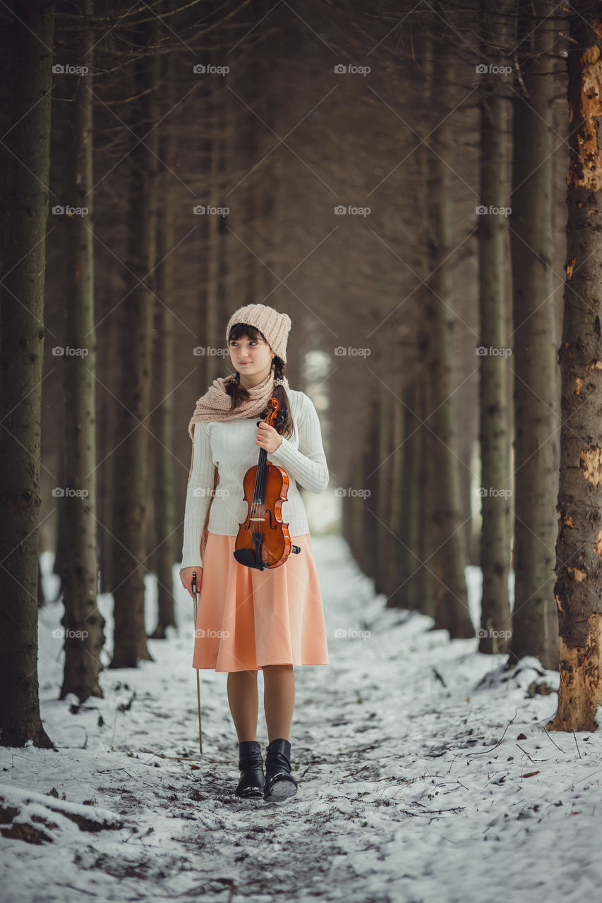 Teenage girl portrait with violin in winter park